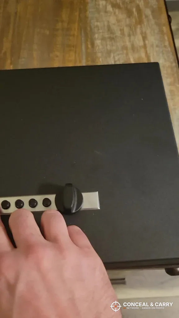 Hand pressing the five push buttons on the V-Line Top Draw lock