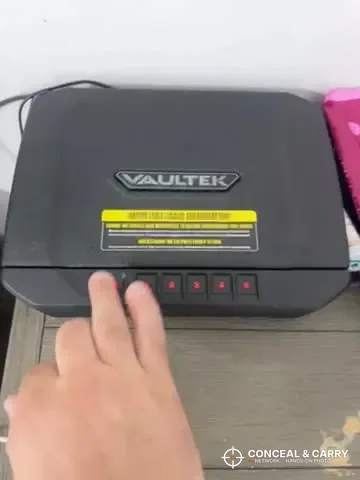 Vaultek 20 Series keypad buttons lit red as a hand reaches to press them