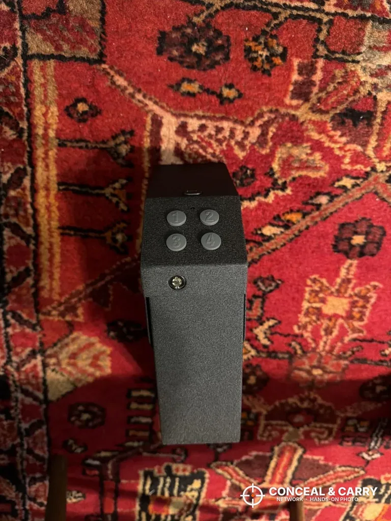 VERPROOF keypad gun safe with four round buttons, standing on a red rug