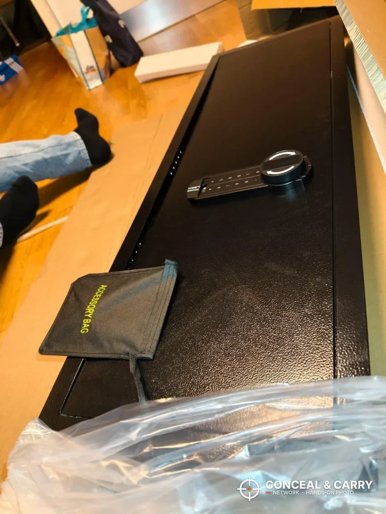 VEVOR hidden wall gun safe half out of its plastic, lying flat with the keypad on the door
