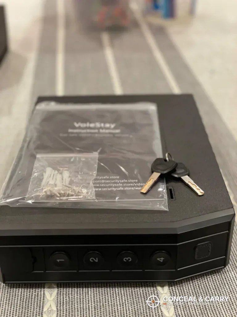 VoleStay slider safe lying flat with its manual, screw bag and keys