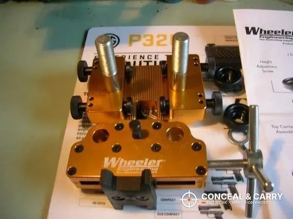 Wheeler sight tool parts laid out on the instruction sheet beside a pistol box