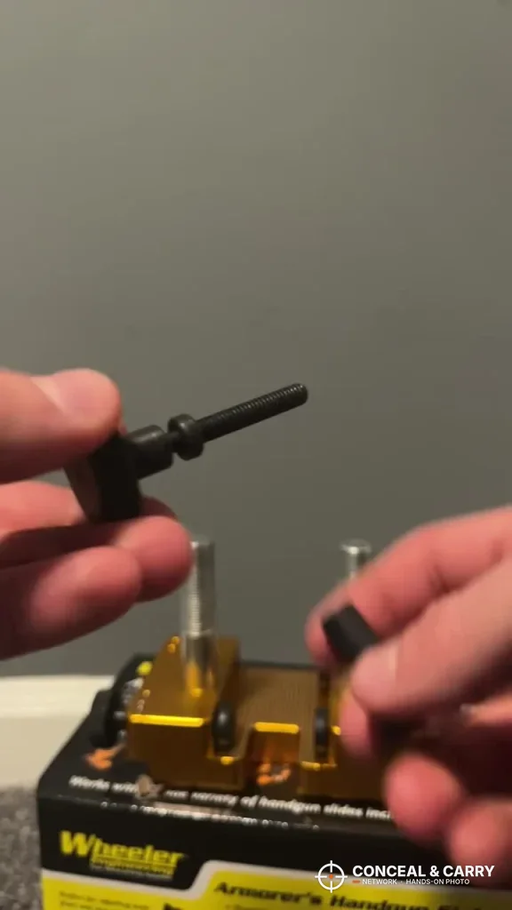 Hands fitting parts to the Wheeler sight tool on top of its retail box