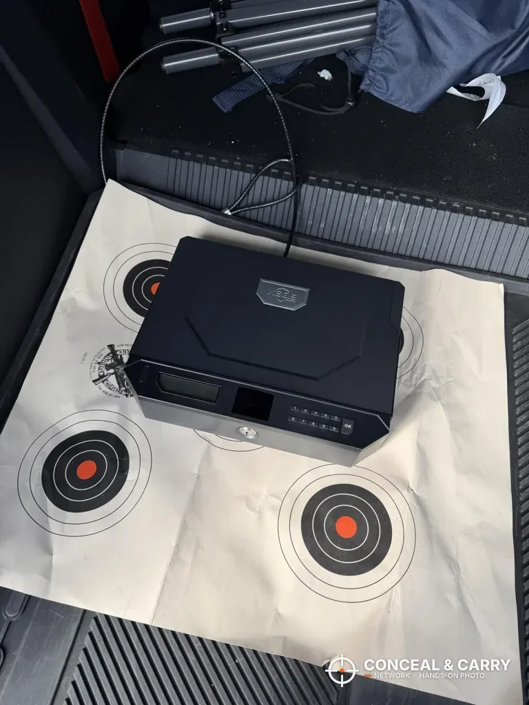 XEGIS gun safe sitting on a paper target with a cable attached