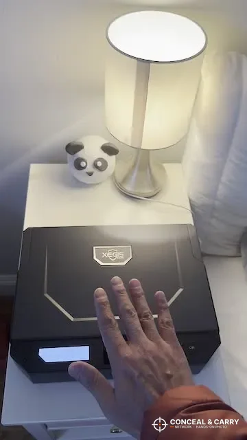 Hand over the XEGIS palm vein safe sensor on a nightstand