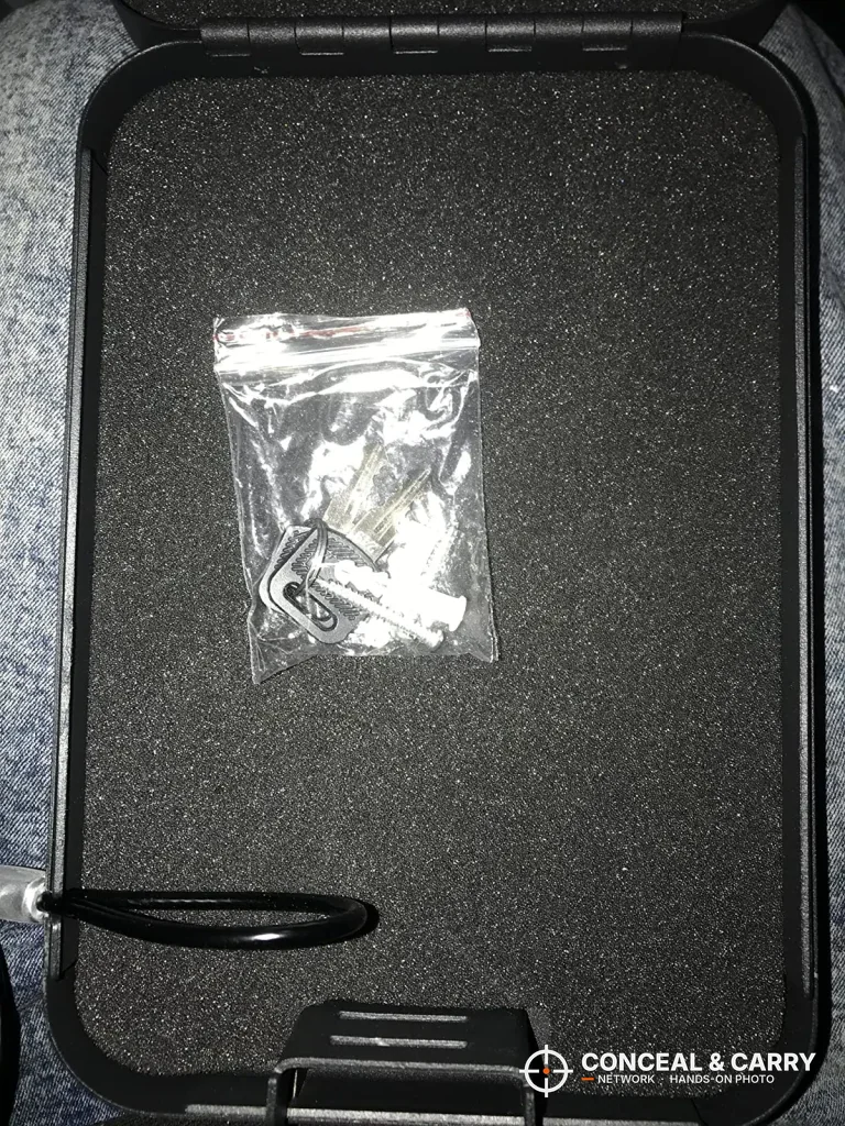 Open Younion pistol safe with a small bag of parts on the foam